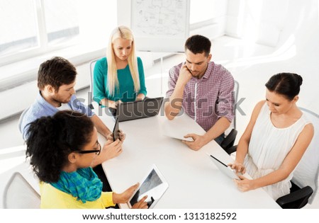 business, technology and startup concept - creative team with table pc computers in office