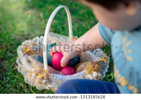a child keeping the easter eggs he has found in a basket on the 