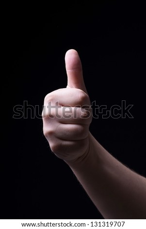 Thumb up on black background
