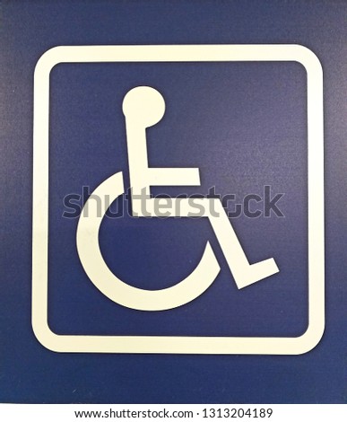 
Wheelchair disabled symbol parking permit signal white painted on the street for handicapped person, Outdoor place no people, no car on a blue background.