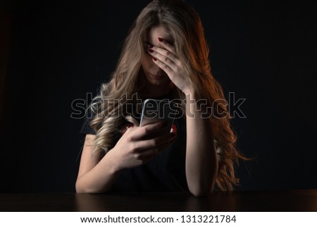 Closeup picture of frustrated girl, young woman being a victim of bullying online