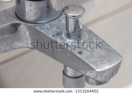 Close-up of shower mixer faucet with limescale, white chalky deposit and stains. Formed on the plumbing system by a combination of soap residues and hard water. Concept of cleaning limescale plumbing Royalty-Free Stock Photo #1313264402