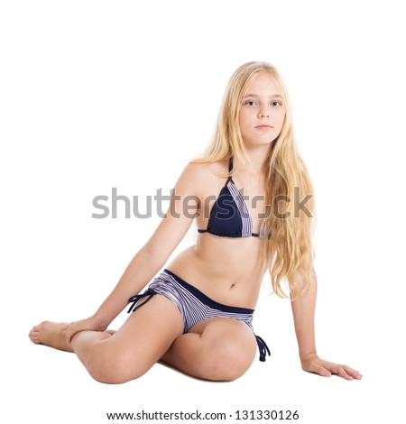 Portrait of a beautiful blonde European girl wearing swimming suit. Girl sitting on the floor. Studio shot, isolated on white background.