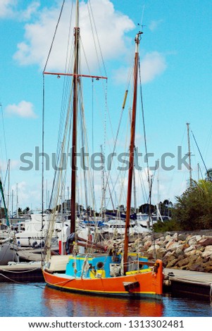 Vintage old style sailing boat berthed at tin Can Bay, Queensland, Australia. Brilliant blue sky backdrop and green tropical palm tree adjacent. Inspirational nautical background image.