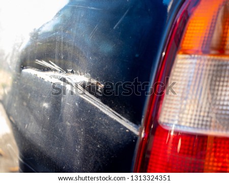 Blue or black car get scratch damaged from accident on the road. White sign on the side. Road accidents.