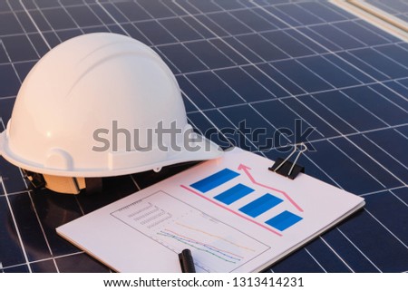 Engineers are examining the performance graph of energy production from solar panels that are alternative energy and which is the concept of sustainable resources.