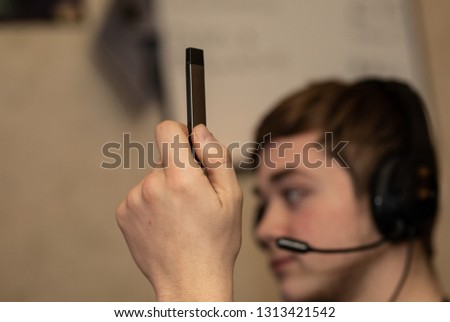 student holds up vape after he is spotted by teacher Royalty-Free Stock Photo #1313421542