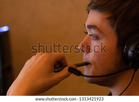 teenager vapes while playing video games Royalty-Free Stock Photo #1313421923