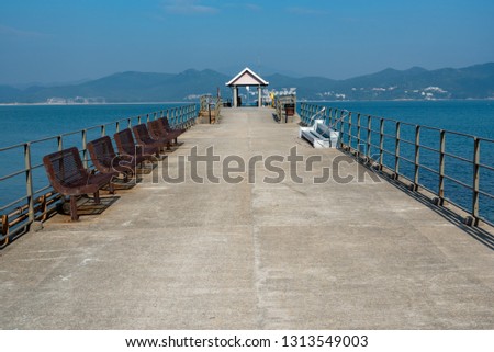 The pier in TUNG PING CHAU HongKong, there are many chairs on the aisle leading to the pier. in the sunny day
