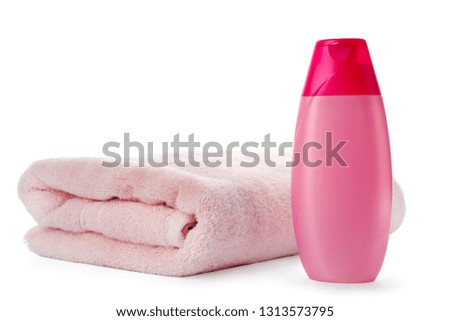 Folded towel and shampoo isolated on white