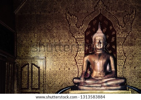 golden buddha image with ancient thai painting style as background at Wat Pipat Mongkol temple, Sukhothai, Thailand