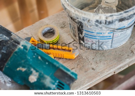 Working gloves. Do makeovers. Putty knife lying on the bucket. Tools for construction and repair. Selective focus