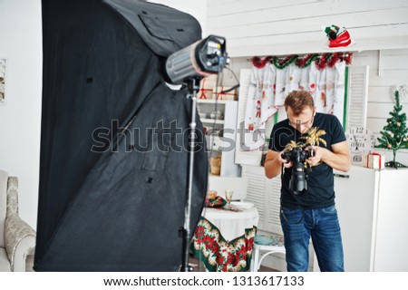 Man photographer looking at camera for result what him shoot on studio. Professional photographer on work.
