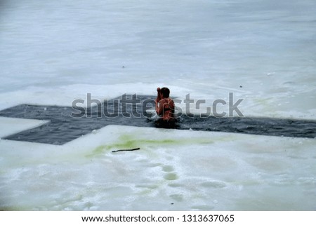 A woman bathes in an ice-hole in the winter in an icy water walrus