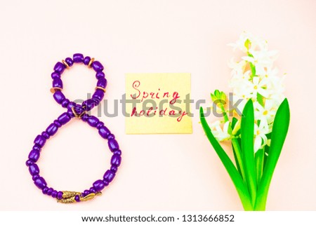 Festive concept. Congratulate on the International Women's Day. Notepad, eight of beads. Place to sign. Congratulations on March 8, spring background pink