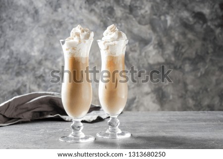Glasses of cold frappe coffee on grey table