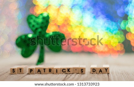 Happy St. Patrick's Day fun rainbow background on wooden board with treasure chest and shamrock and gold coins, selective focus, shallow DOF