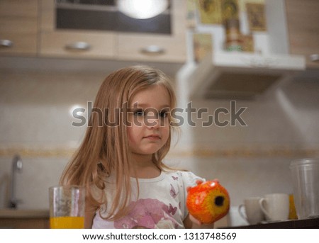 Little girl holding fruits.
