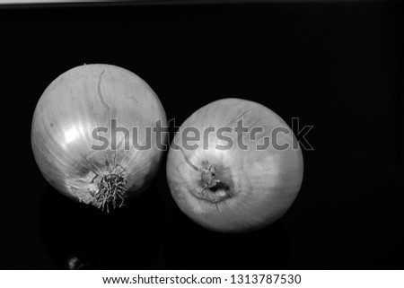 onions reflected on a black mirror table