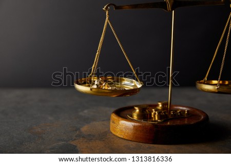 golden stones on scales on marble surface and black background