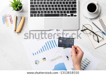 Concept of a woman is doing a online purchase, mock up card and cellphone on office desk isolated on beautiful fashion marble background, copy space, top view, flat lay, closeup