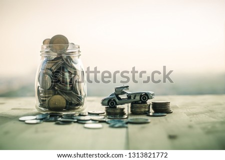 Toy cars and coins in a dozen that contain a lot of money with a beautiful backdrop showing the money to buy cars.
