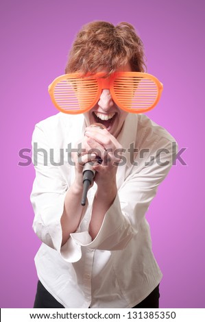 funny business woman singing with big orange eyeglasses on pink background