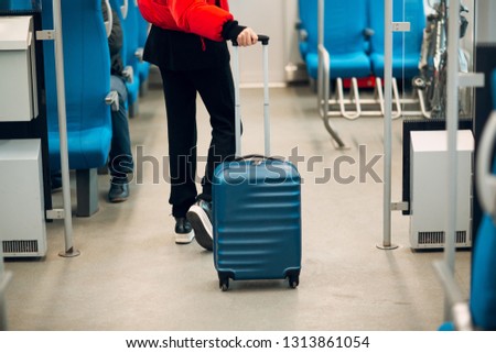 Young female and luggage in railway train.