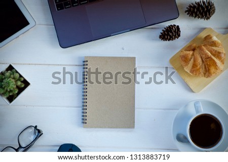 Desk work laptop notebook pen and coffee cup hot on wooden table