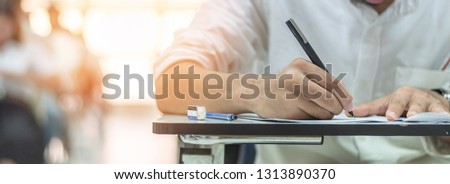 School exam, student taking educational admission test in class, thinking hard, writing answer in university classroom, education and world literacy day concept Royalty-Free Stock Photo #1313890370