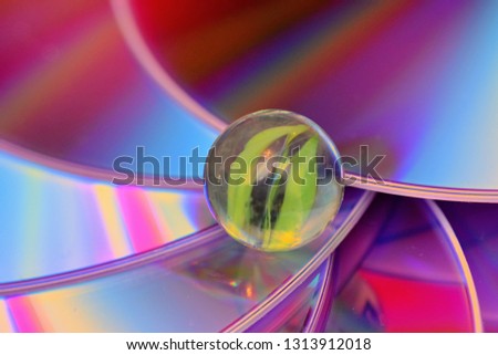 Close up photo of marbles and old CDs under the different light forming the interesting coloured backgrounds that looks lika abstract cosmos