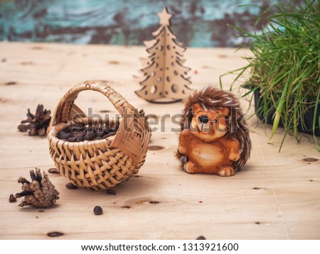 Greeting card with a toy hedgehog. Hedgehog gathered in the forest a basket of pine nuts.