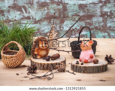 A fabulous picture with small toys, a Hedgehog and a pink pig are resting on stumps, tired of harvesting nuts in the forest