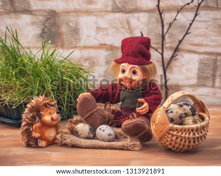 A fantastic card with little toys. The forester and hedgehog are talking, they are sitting next to the forest clearing, next to them is a basket of quail eggs