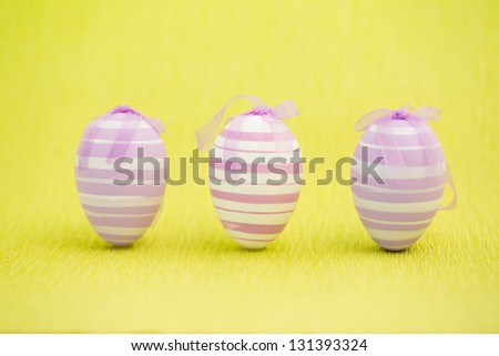 Purple easter eggs standing against yellow background