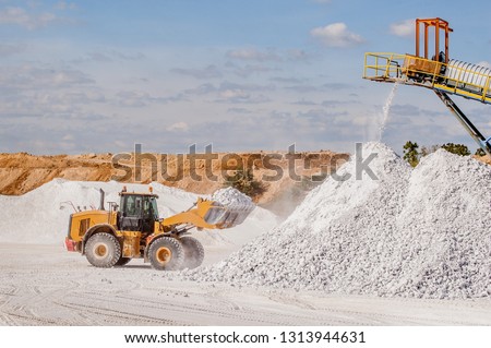 Front end loader and gypsum stock pile Royalty-Free Stock Photo #1313944631