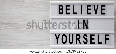 'Believe in yourself' words on modern board on a white wooden surface, top view. From above, flat lay, overhead. Space for text.