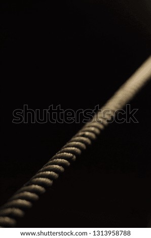straight rope on a black background is illuminated with light