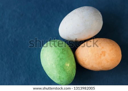 Several multi-colored decorative eggs on blue background. Easter concept.