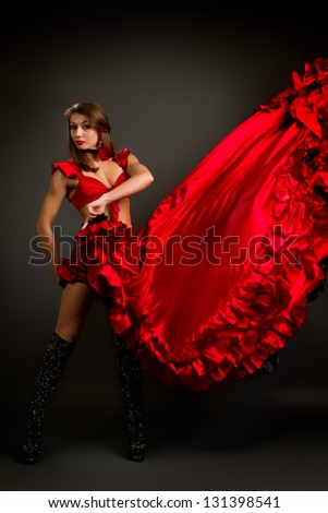 Close-up photo of the lady in gypsy costume dancing flamenco  on a gray background