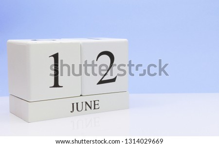 June 12st. Day 12 of month, daily calendar on white table with reflection, with light blue background. Summer time, empty space for text