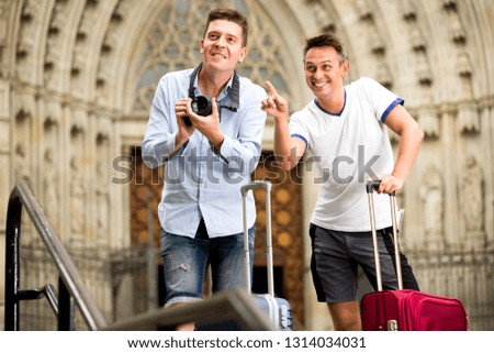 Positive young male couple sightseeing and taking pictures of Europenian city
