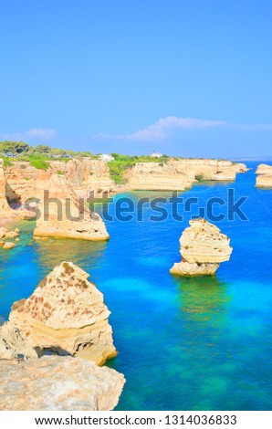 Beautiful view of the bay in portuguese Algarve taken on a sunny day with amazing sea cliffs and popular Marinha beach. The southern coast of Portugal is a famous summer vacation destination. 