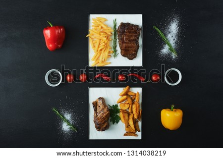 The concept of artistic paintings from vegetables. Delicious grilled steak with vegetables tomatoes and fries