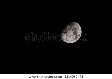 Photograph of the moon against a starry night.