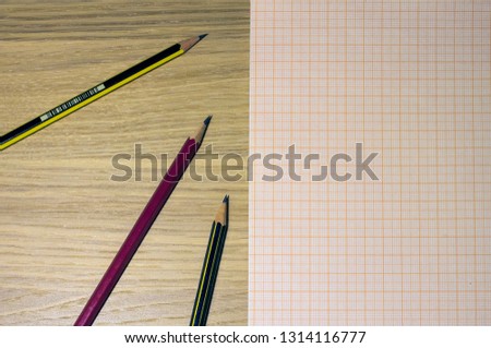 pencils on oak table and graph paper