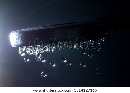 Modern shower with stream drops of water and sunlight bokeh close-up macro on a dark background