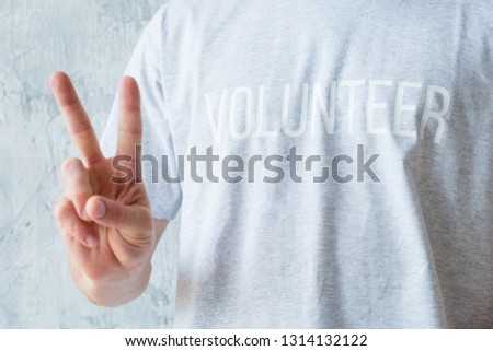 Volunteering activity. Modern lifestyle concept. Man in tshirt showing V sign. Royalty-Free Stock Photo #1314132122
