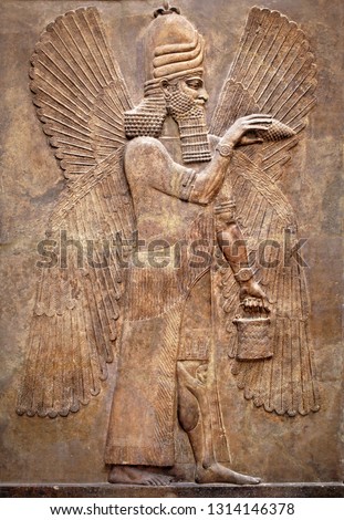 Sumerian wall relief of winged genius from Mesopotamia. Carving panel with Babylonian god, art of Ancient Babylon. Monument of past civilization culture. History of Iraq and Mesopotamia theme. Royalty-Free Stock Photo #1314146378