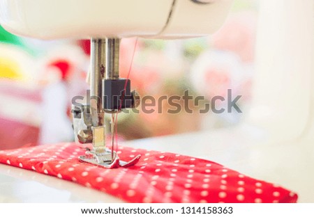 Close up of sewing machine working with red fabric